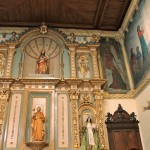 Fotografía detalle del retablo de la Capilla de la Oficina del Peregrino en donde se observan varias figuras y algunos frescos.